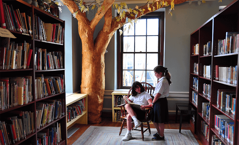 girls reading in library with tree