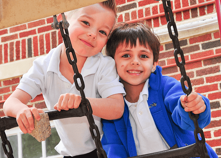 two young boys playing together on playset